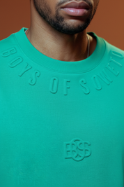 Turquoise Boys of Soweto T-shirt with terracotta background